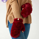 closeup of woman wearing mersea cozy cabin faux fur mittens in wine color