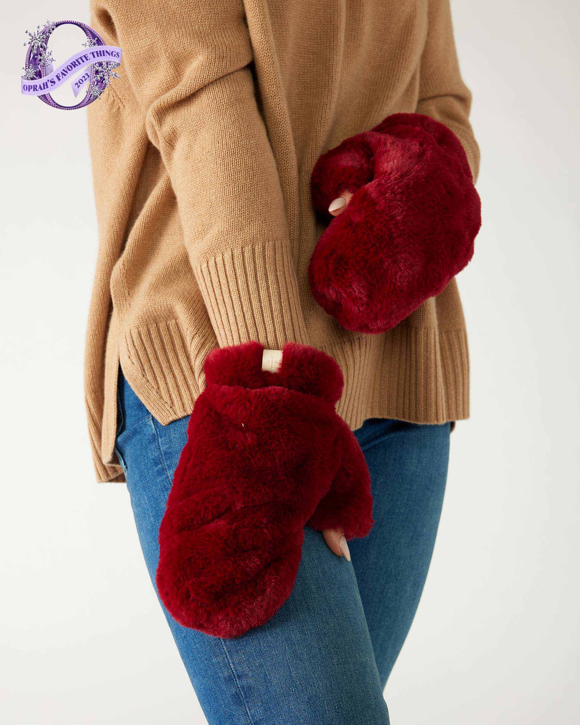 closeup of woman wearing mersea cozy cabin faux fur mittens in wine color