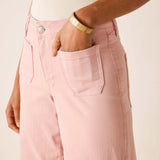 Person wearing pink pants with a beige background