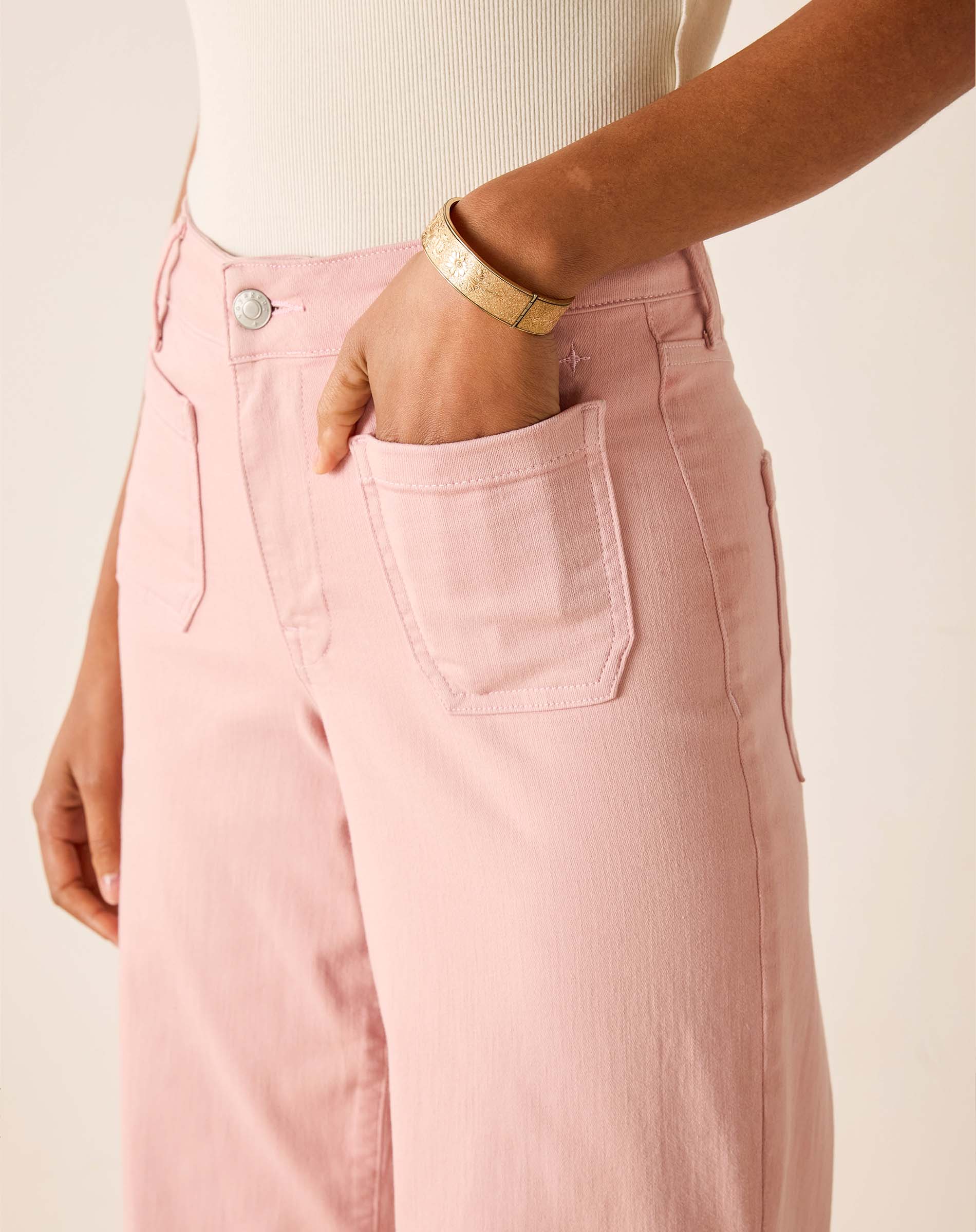 Person wearing pink pants with a beige background