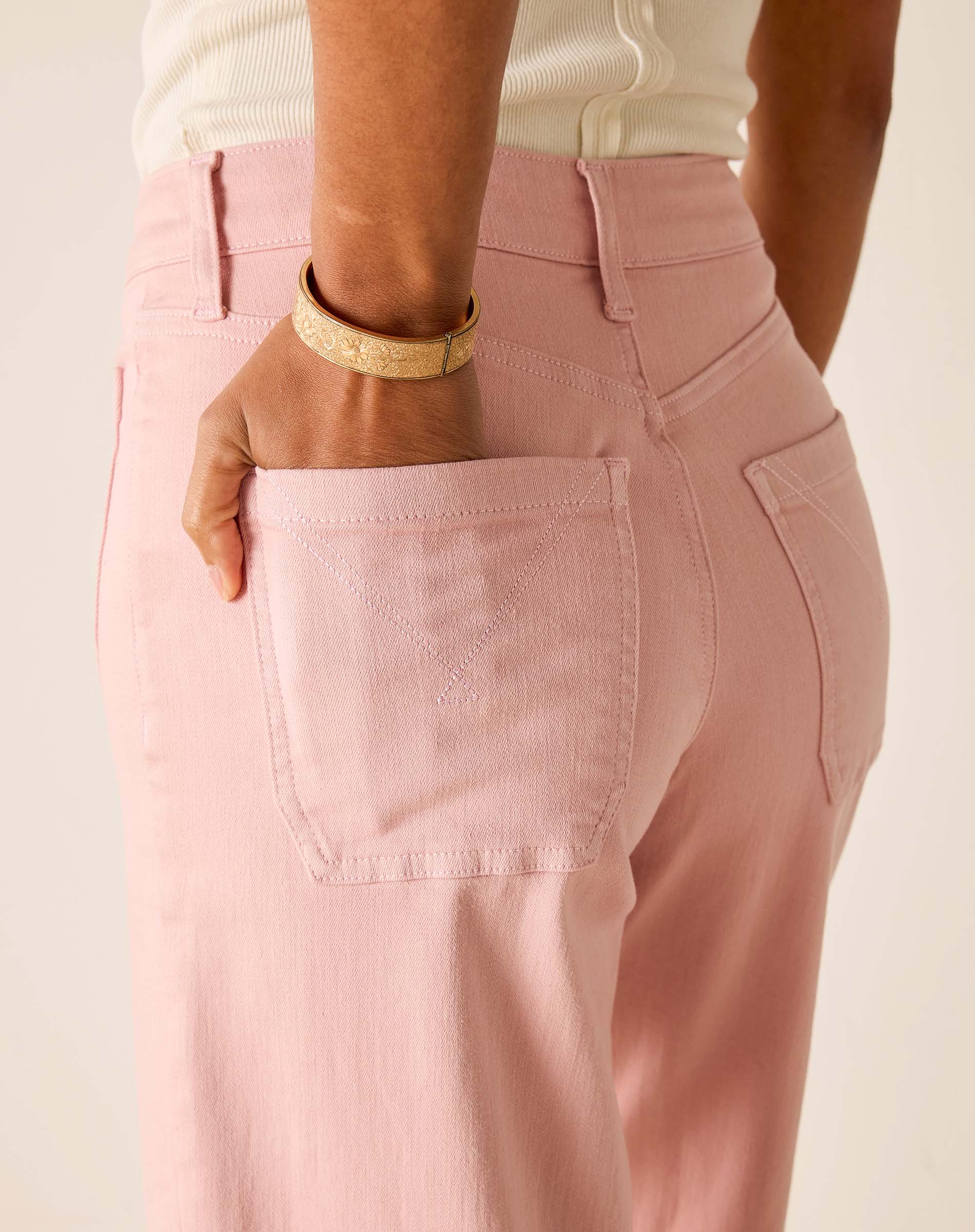 Person wearing pink pants with a neutral background