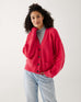 woman wearing hibiscus red buttoned mersea cruiser cardigan on a white background