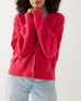 closeup of woman wearing hibiscus red buttoned mersea cruiser cardigan on a white background