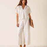 Woman wearing a white outfit with a plain background