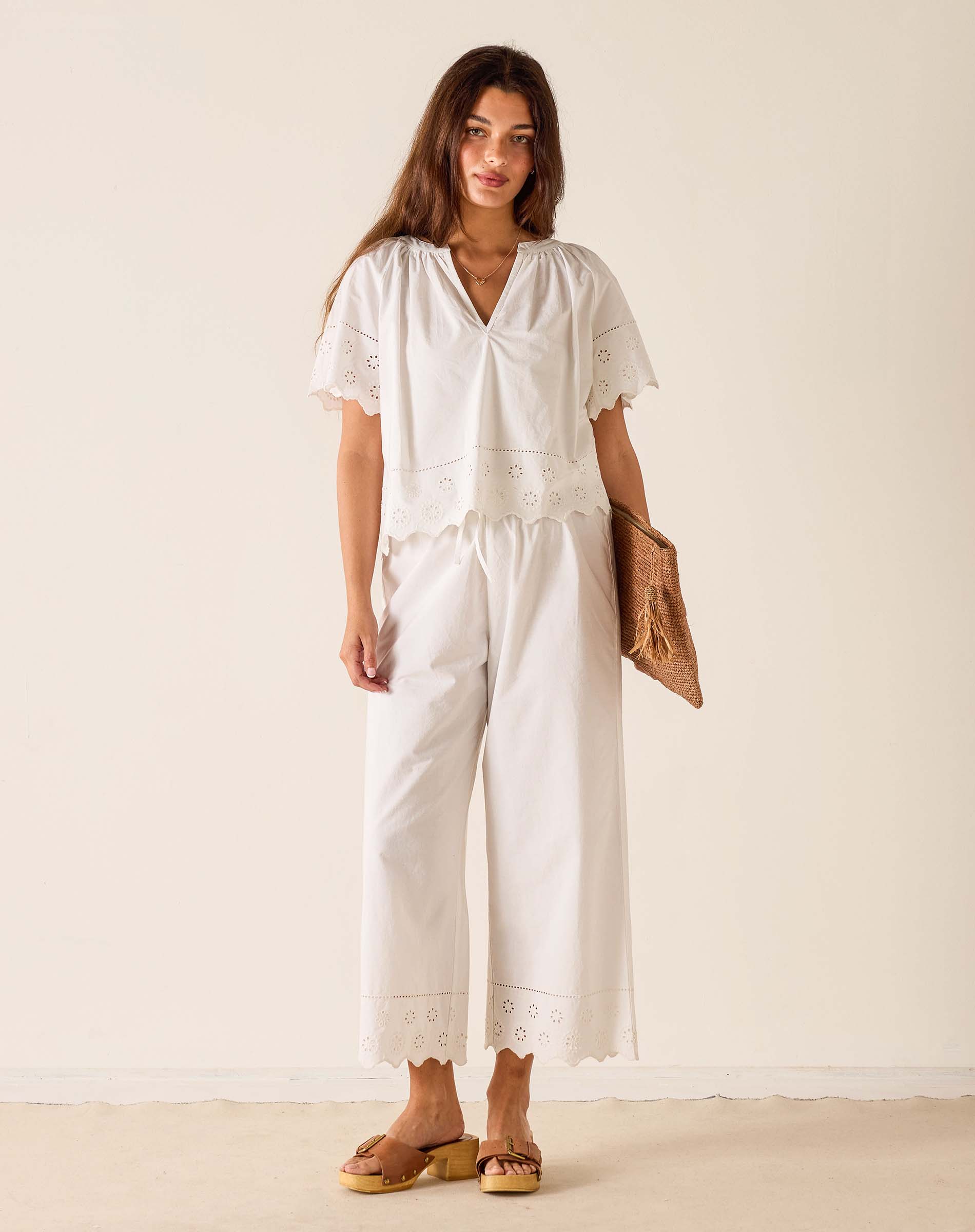 Woman wearing a white outfit with a plain background