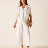 Woman wearing a white jumpsuit with a plain background
