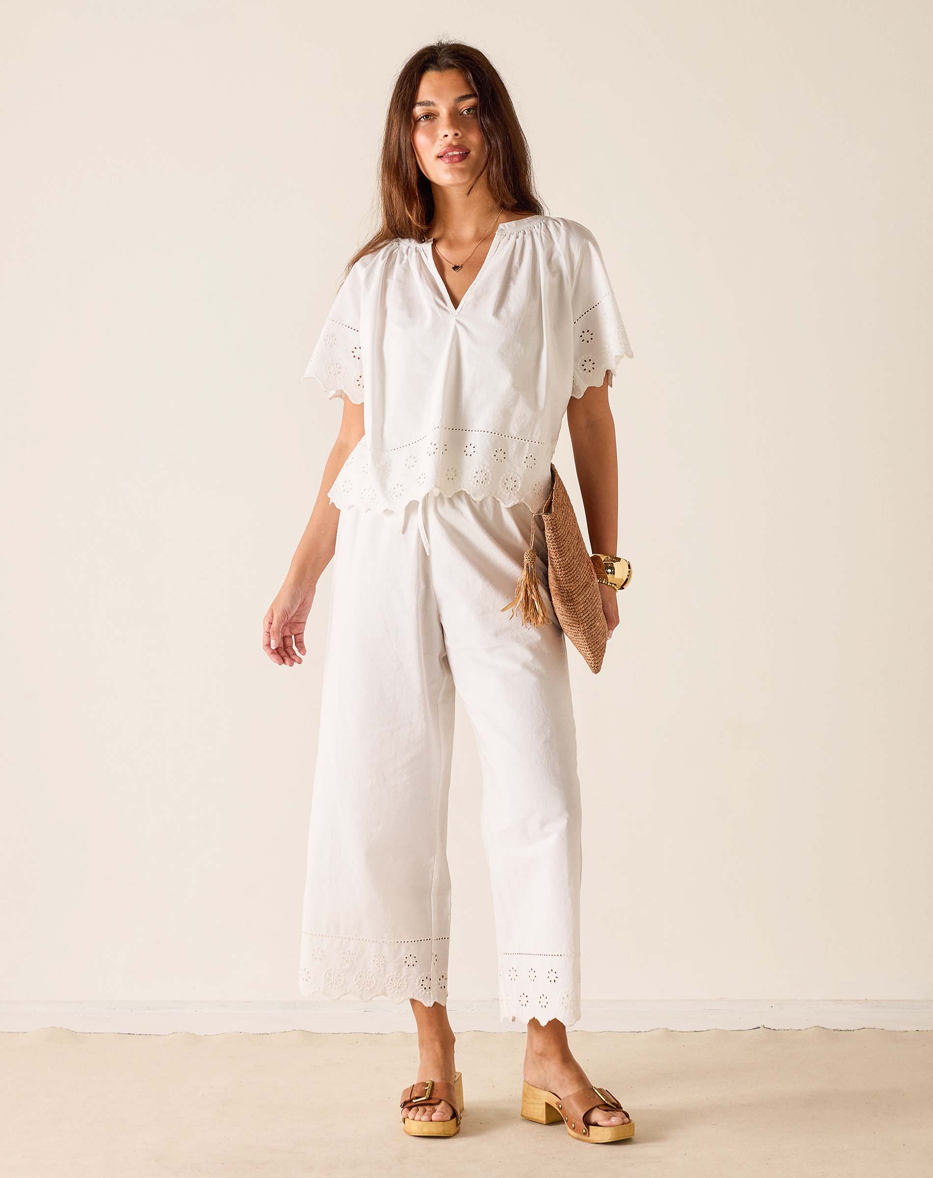 Woman wearing a white jumpsuit with a plain background
