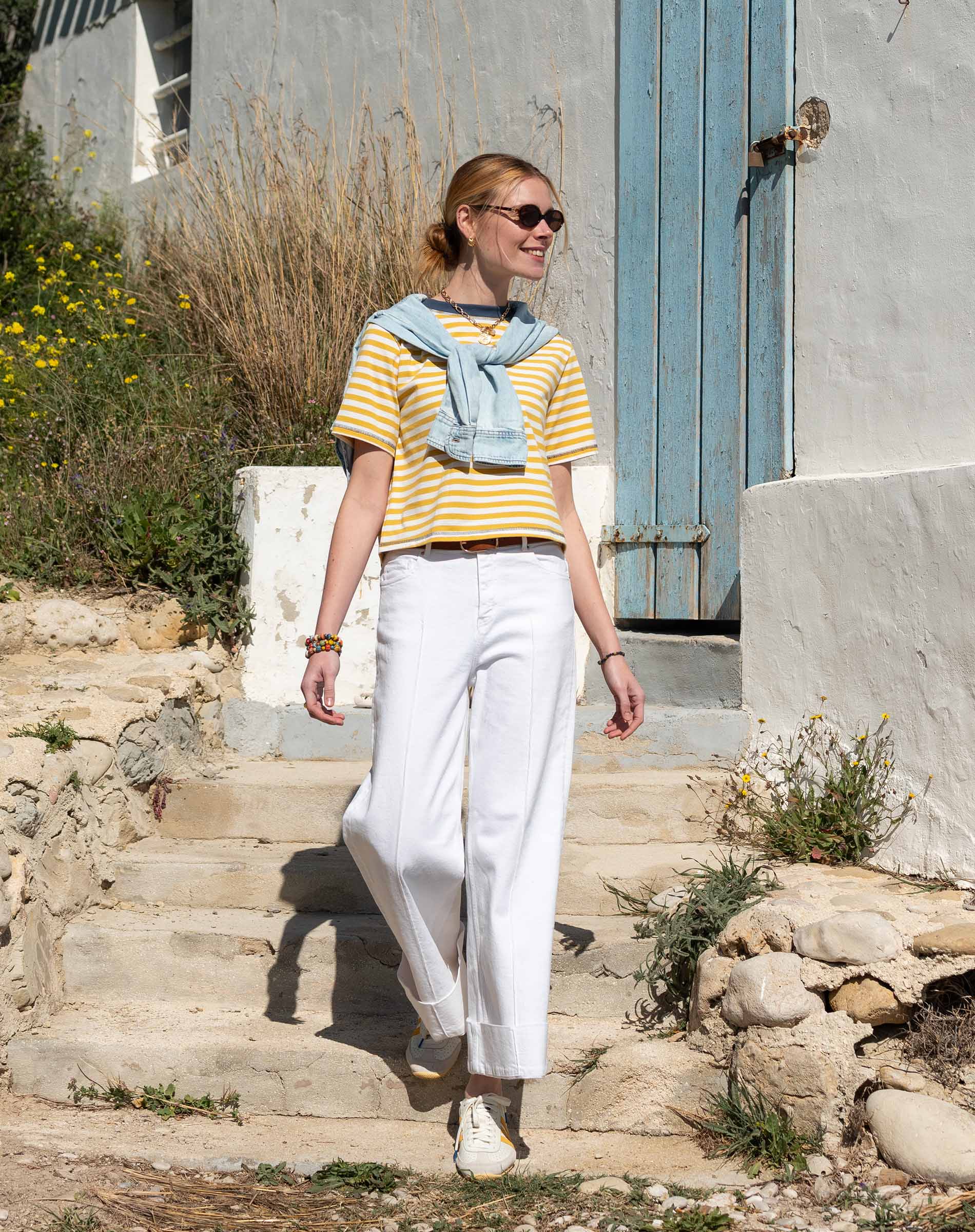 MERSEA women's travel-friendly women's travel-friendly golden rod and indigo striped ringer tee paired with white high-waisted wide-leg pants.