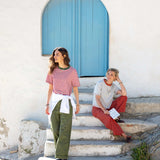 MERSEA ladies' travel-ready ladies' travel-ready slate blue and persimmon striped ringer tee worn by a woman in front of a blue door.