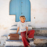 Slate blue and persimmon striped ringer tee with wide-leg pants in a coastal setting.