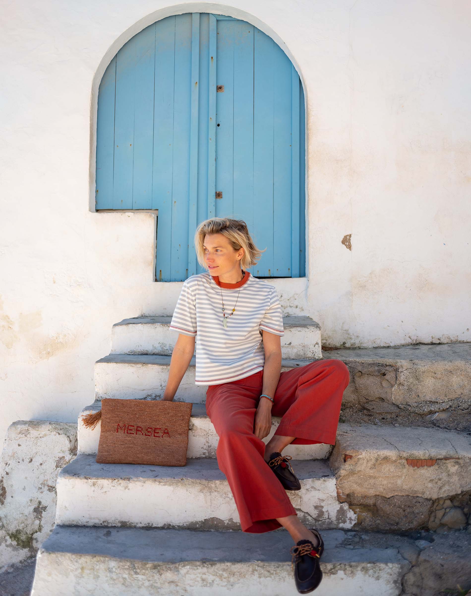 Slate blue and persimmon striped ringer tee with wide-leg pants in a coastal setting.
