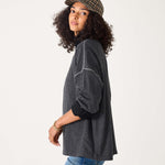 Woman wearing a dark gray sweater and plaid cap on a white background