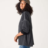 Woman wearing a dark gray sweater and plaid cap on a white background