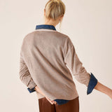 Back view of the fawn knit sweater with denim accents at the collar and cuffs.