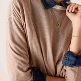 Fawn knit sweater with a layered denim collar and cuffs.