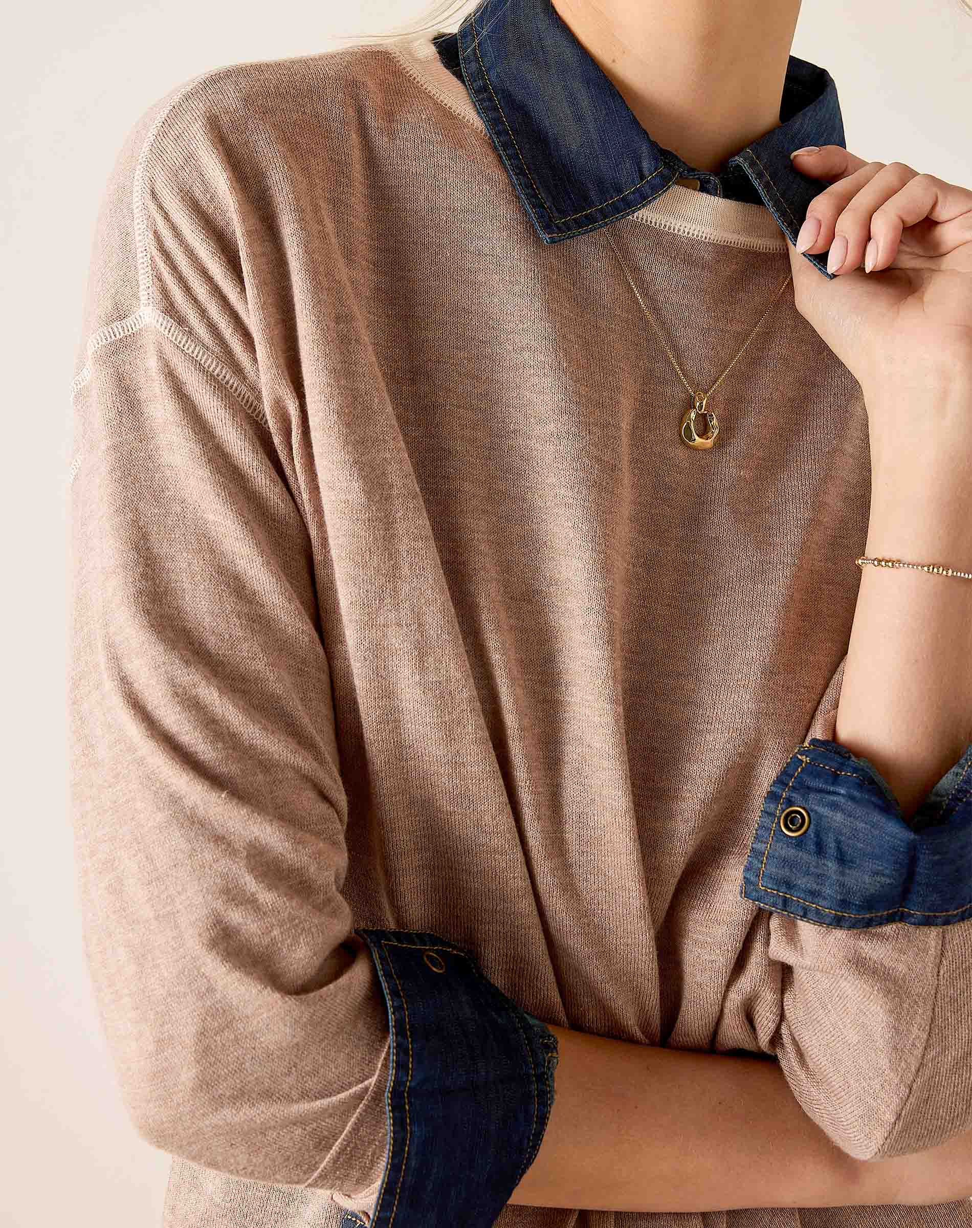 Fawn knit sweater with a layered denim collar and cuffs.