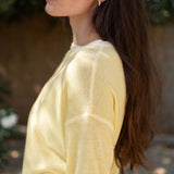 Woman wearing a yellow sweater with a blurred background