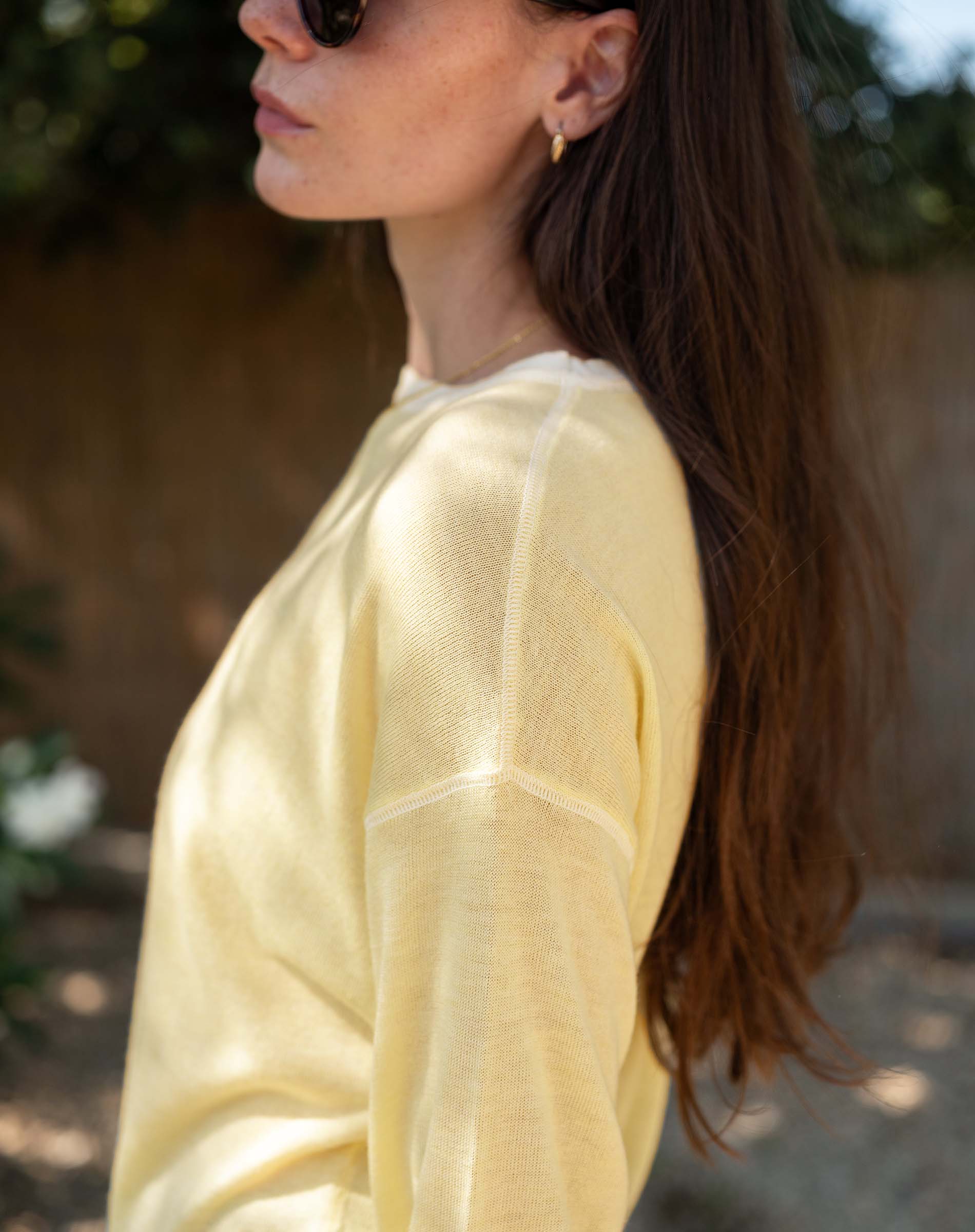 Woman wearing a yellow sweater with a blurred background