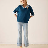 MERSEA ladies' travel-ready deep teal v-neck knit top with a white striped collar and wide-leg jeans.
