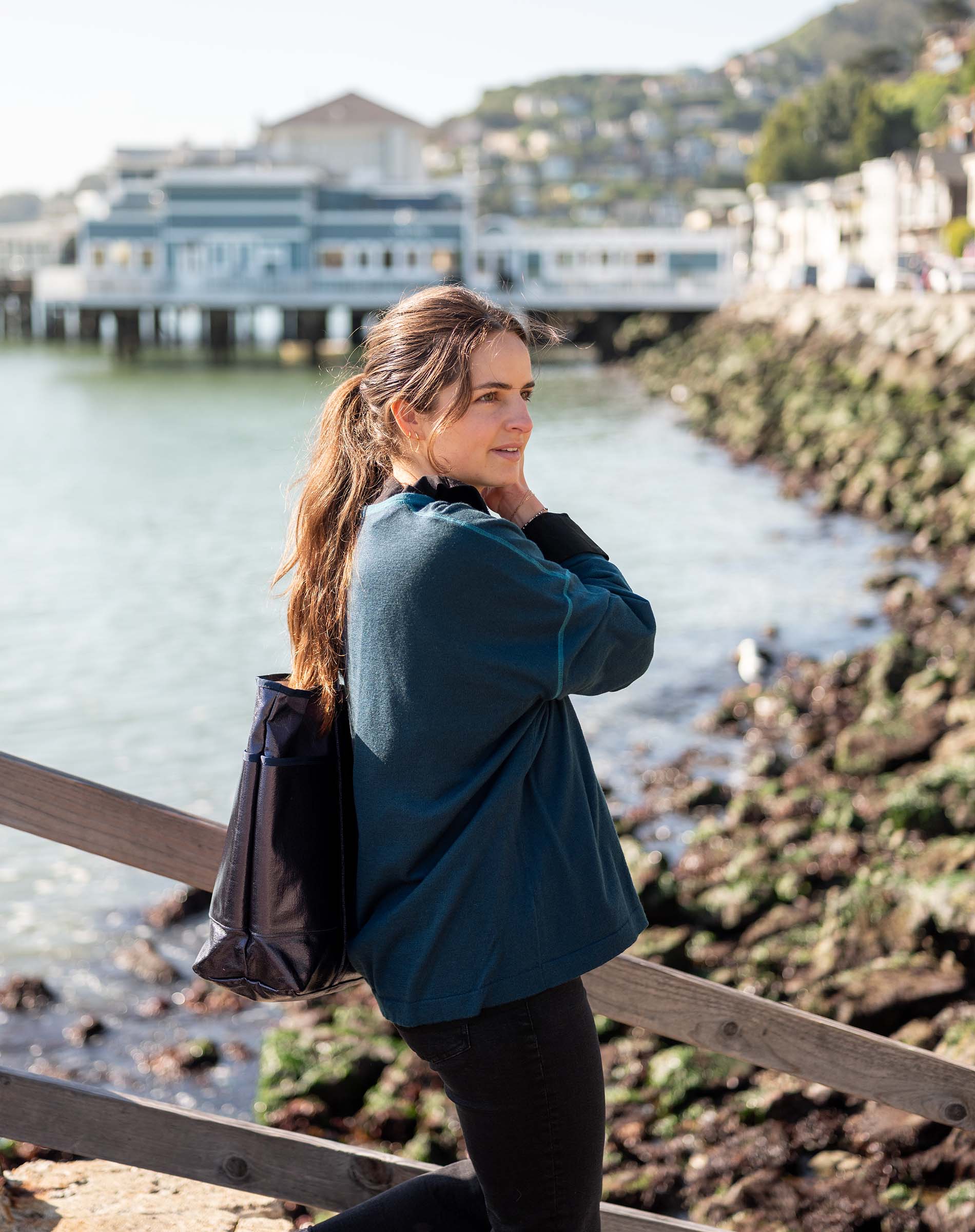 Woman standing by a waterfront with a scenic background