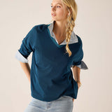 Deep teal v-neck knit top with flared sleeves and a light blue collared shirt underneath