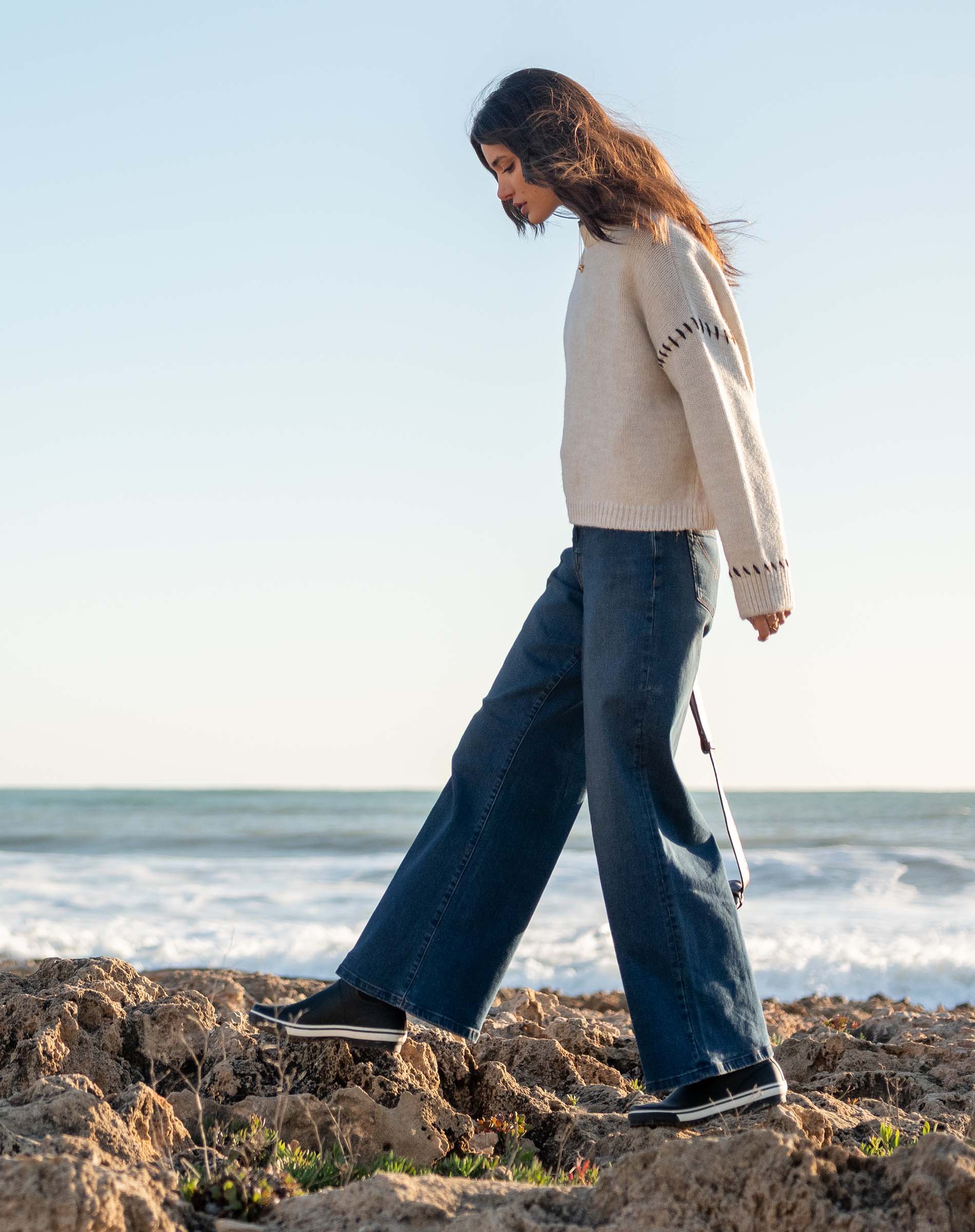 Cream whipstitch knit sweater featuring a side detail.