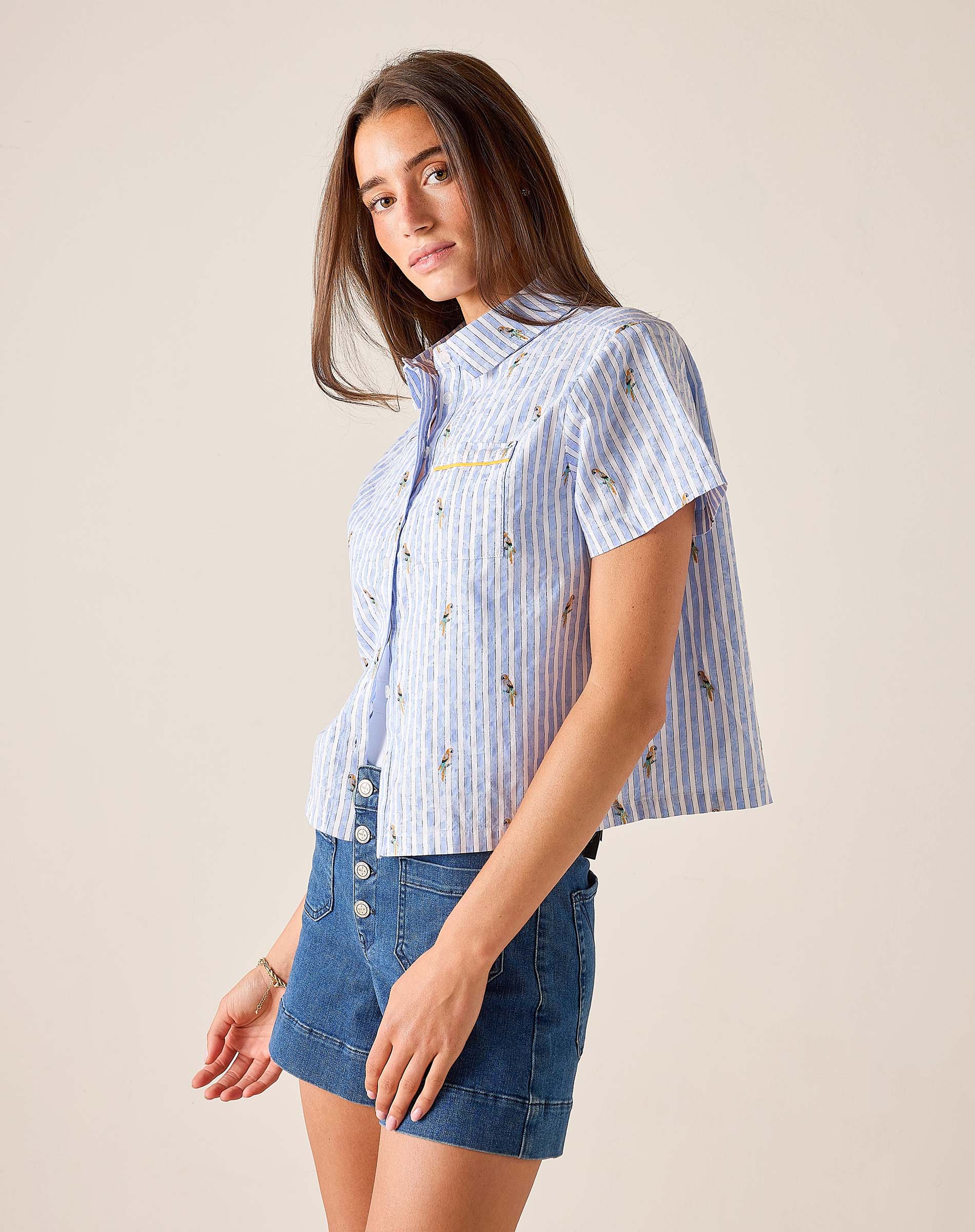 Woman wearing a blue and white striped shirt with a plain background