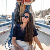 Woman sitting on a dock with boats in the background