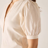 Beige blouse with puff sleeves on a plain background