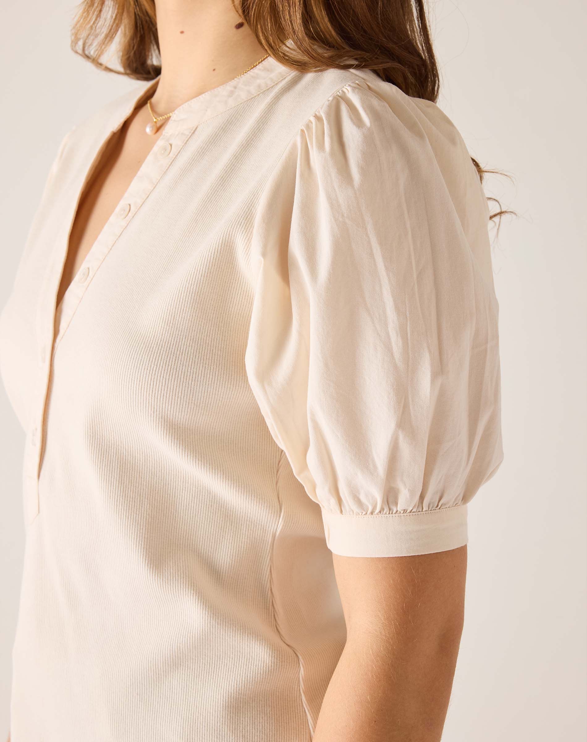 Beige blouse with puff sleeves on a plain background
