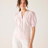 Woman wearing a light pink blouse with puff sleeves against a white background