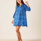 Woman wearing a blue patterned dress against a white background