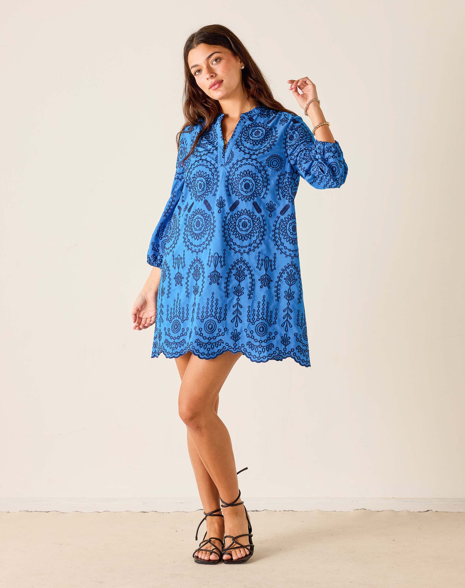 Woman wearing a blue patterned dress against a white background
