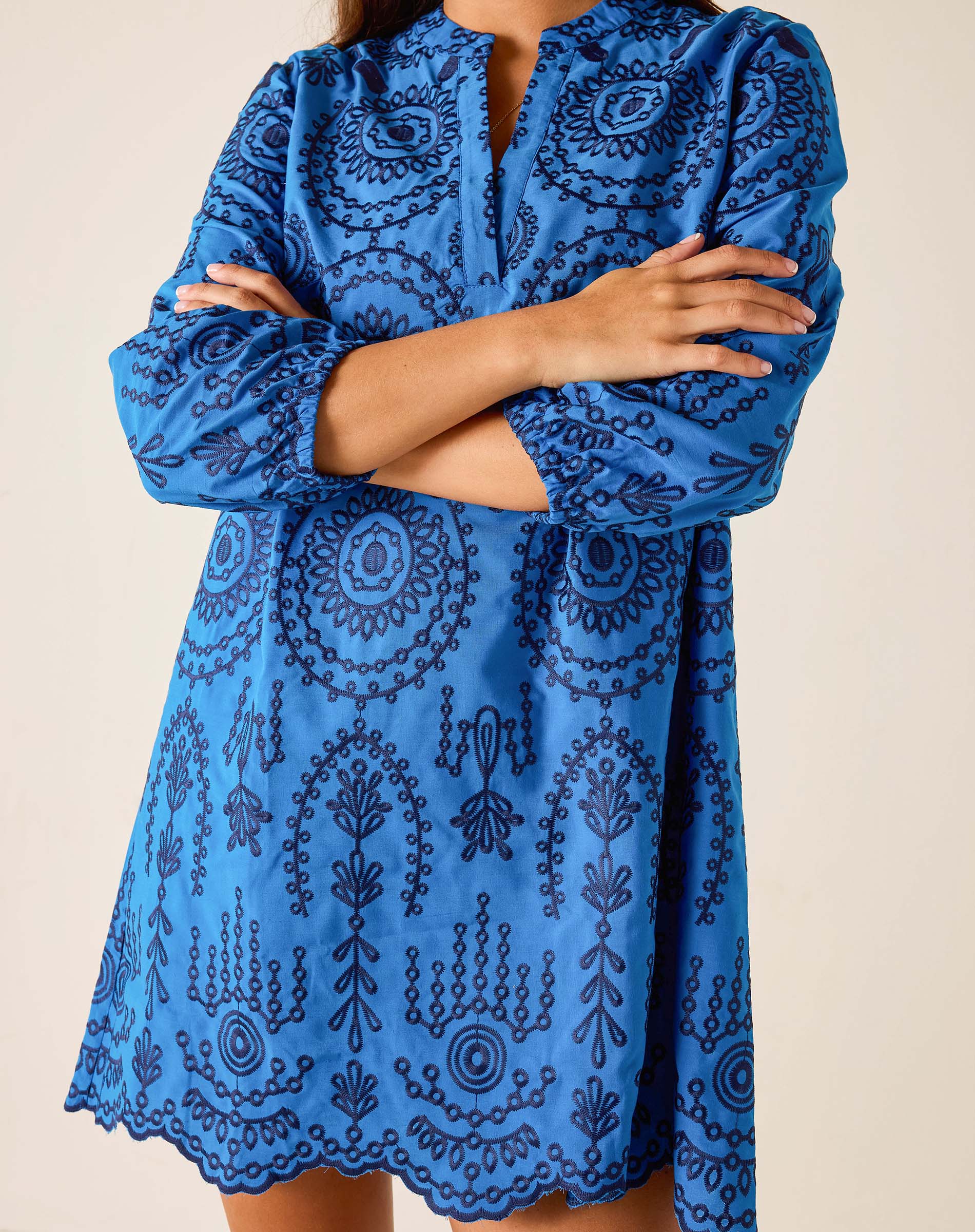 Blue patterned dress worn by a person on a beige background
