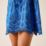 Blue dress with black pattern on a beige background