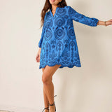 Woman wearing a blue lace dress against a white background