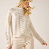 Cream cable knit sweater featuring a chunky ribbed and cable-stitch texture.