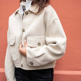 Dove ivory knit jacket with a collar and front pockets.