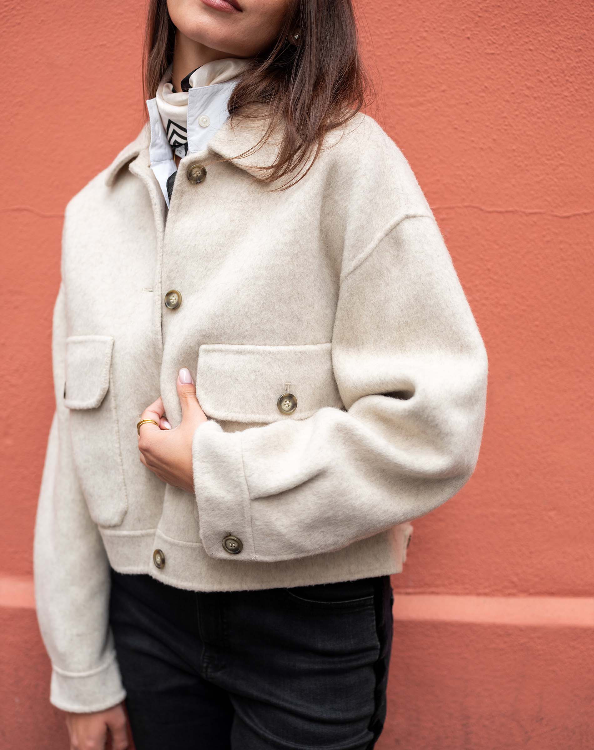 Dove ivory knit jacket with a collar and front pockets.