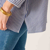 Close-up of a person wearing a blue and white striped shirt and blue jeans on a white background