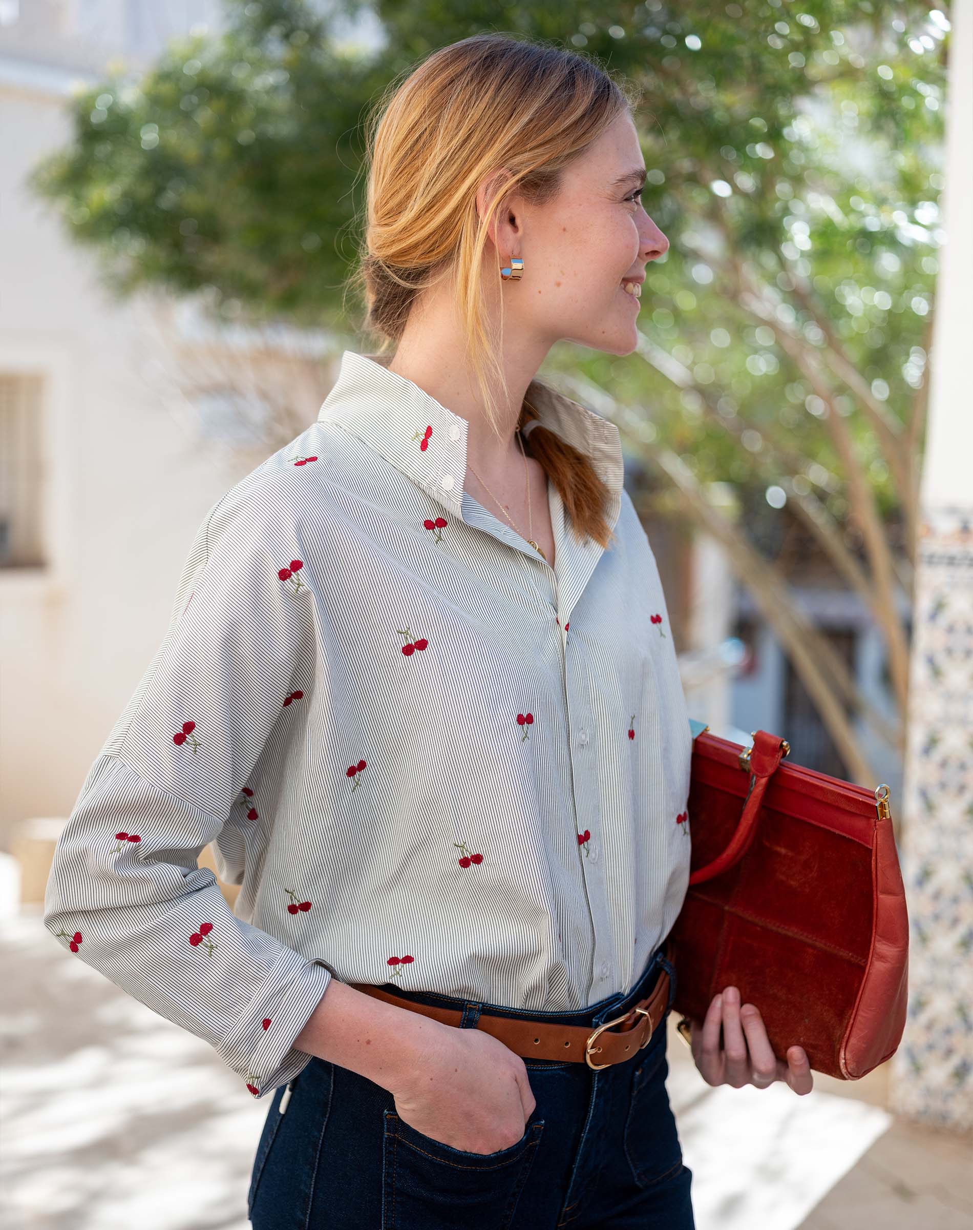 Light blue button-down shirt with a red cherry print and rolled sleeves.