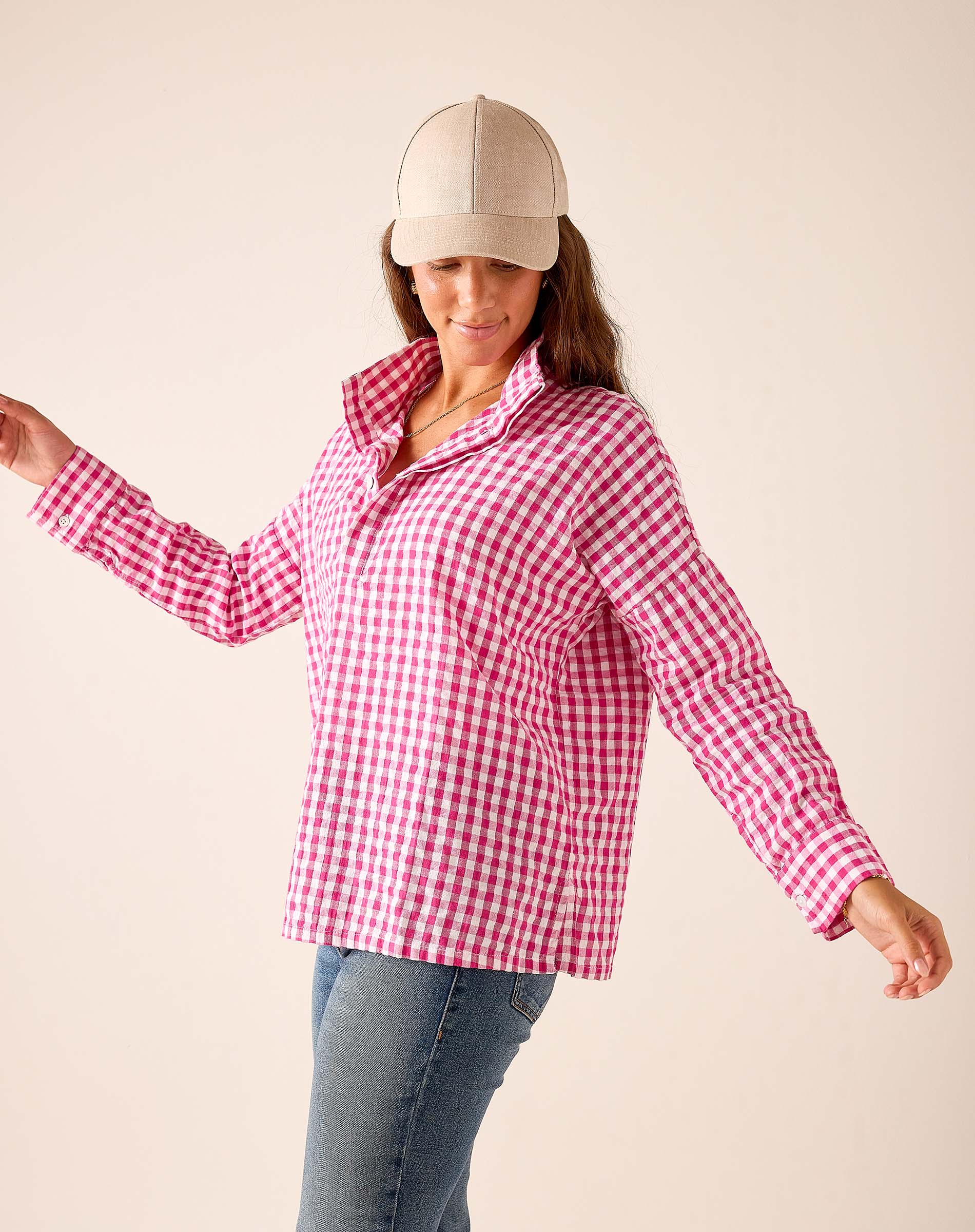 Pink gingham button-down shirt with a collar and long sleeves.
