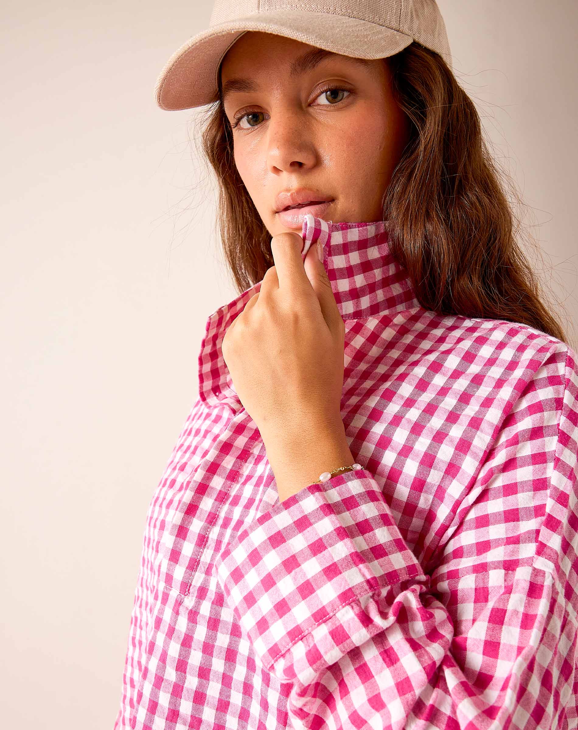 Dark pink gingham shirt with a buttoned collar and long sleeves.