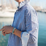 Blue double stripe top with an Elizabethan collar and statement sleeve cuff.