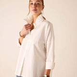 White ruffled Elizabethan collar top featuring button detailing and rolled sleeves.