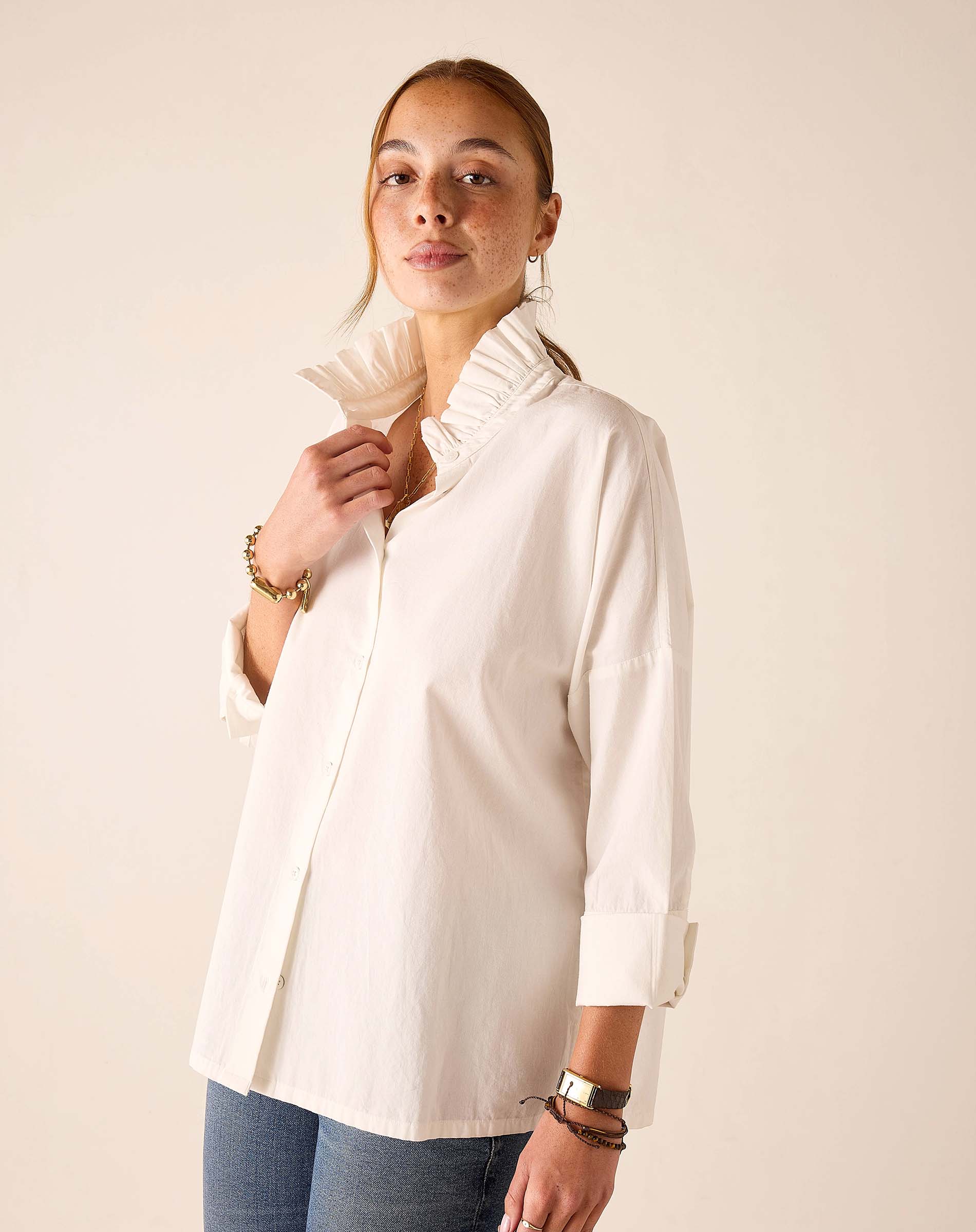 White ruffled Elizabethan collar top featuring button detailing and rolled sleeves.