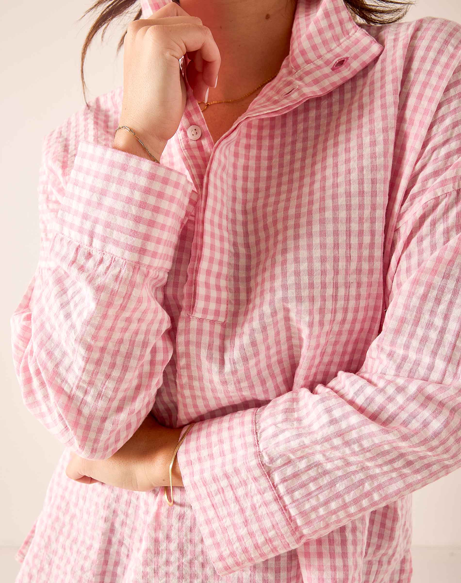 Light pink gingham button-down shirt with ruffled sleeves and a collar.