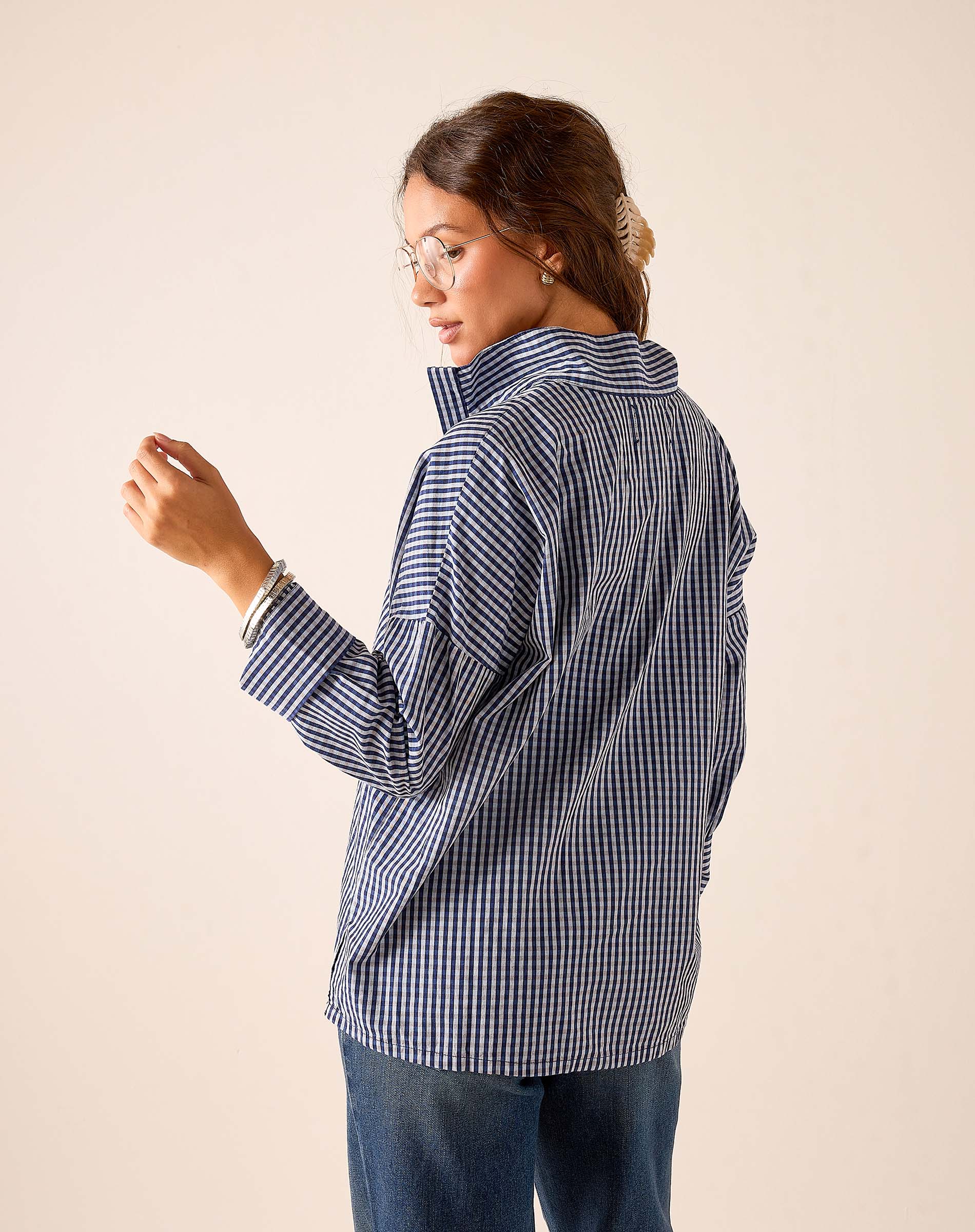 Side view of women's travel-friendly navy gingham button-down shirt.