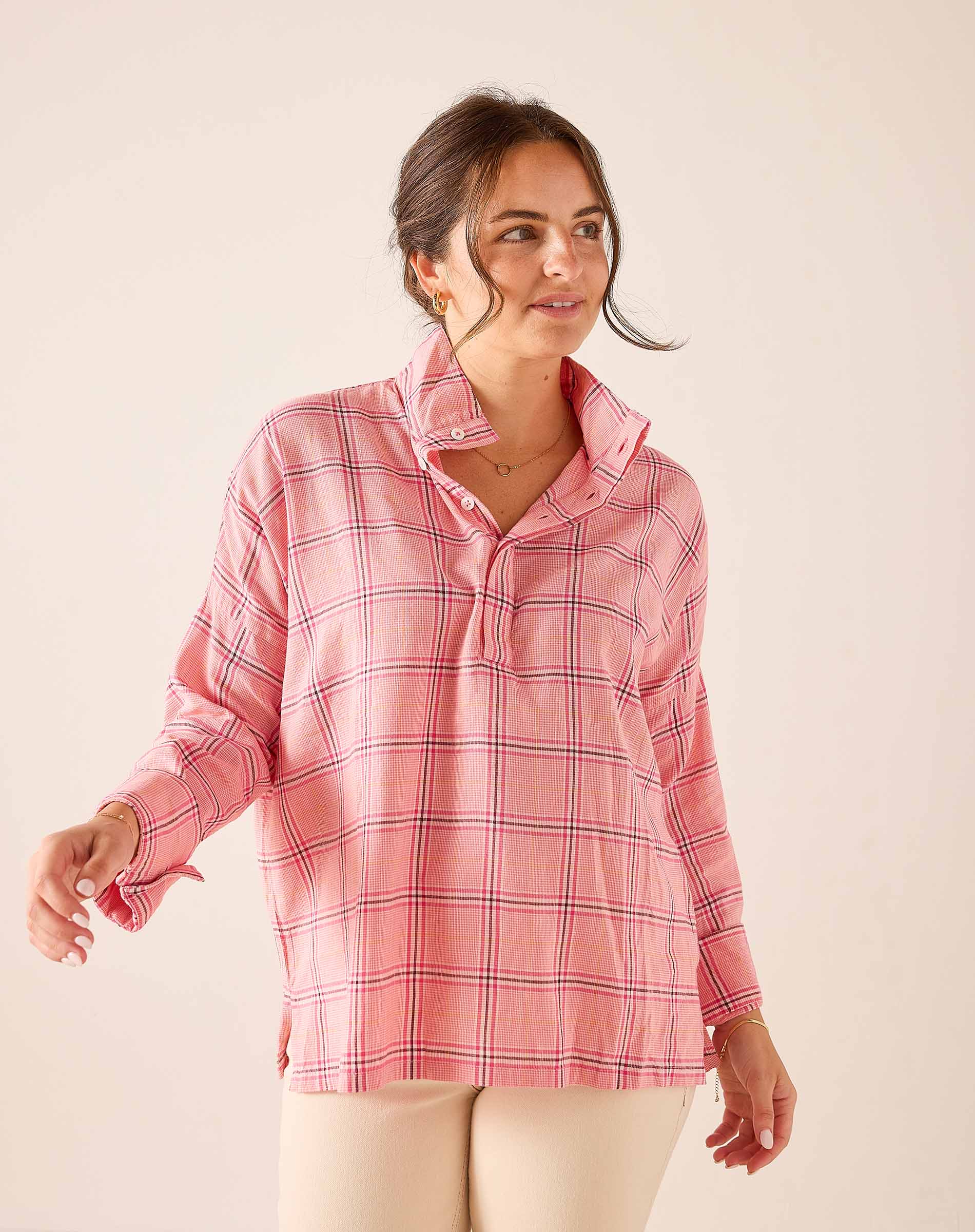 Pink plaid button-down shirt with a relaxed fit and long sleeves.