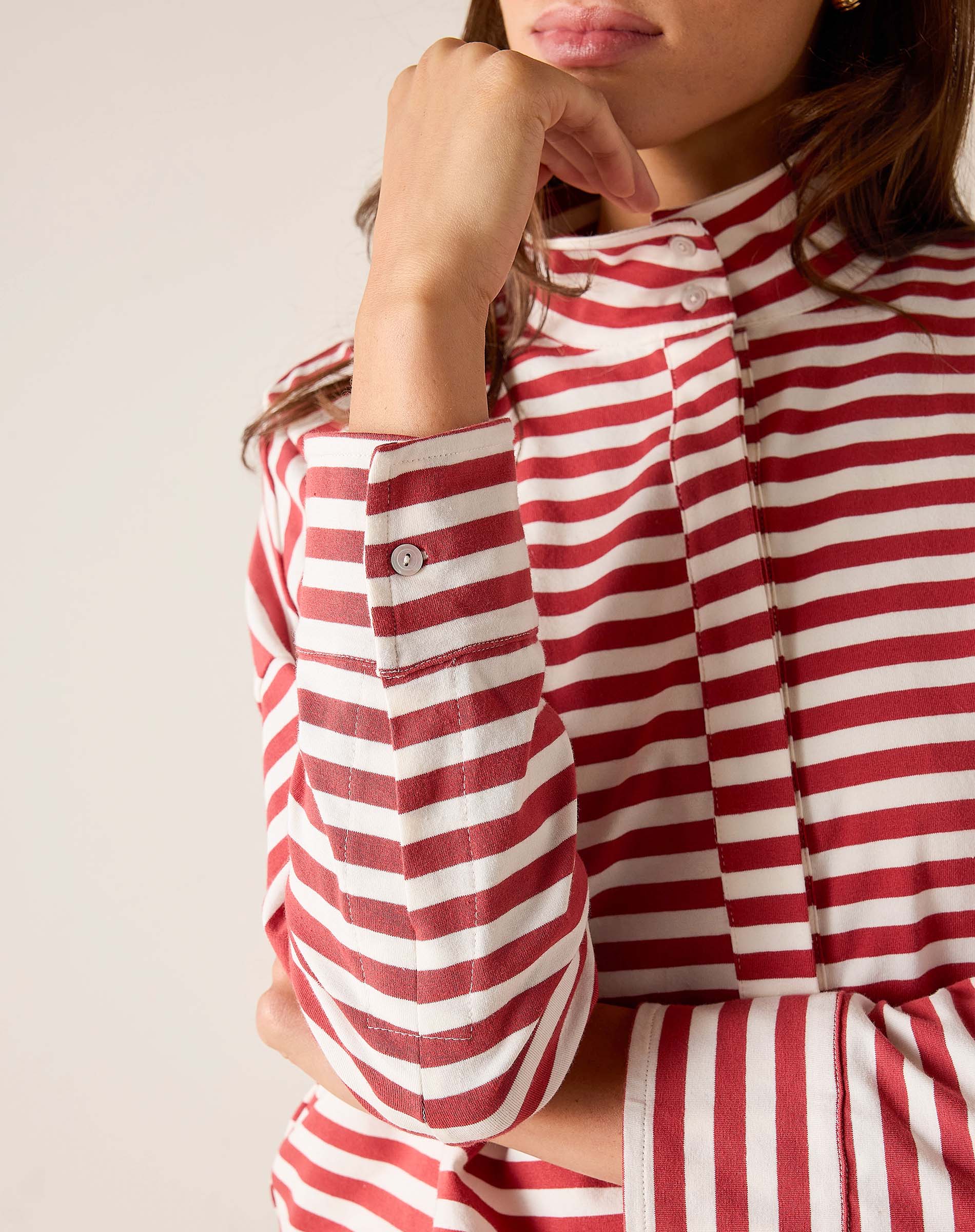 Red and white striped shirt worn by a person on a plain background
